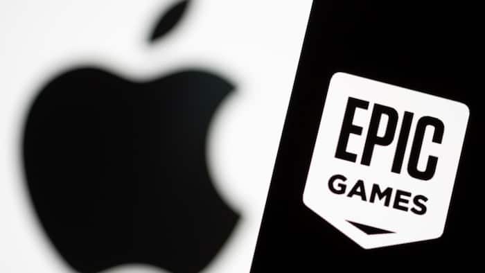 Smartphone with Epic Games logo is seen in front of Apple logo in this illustration