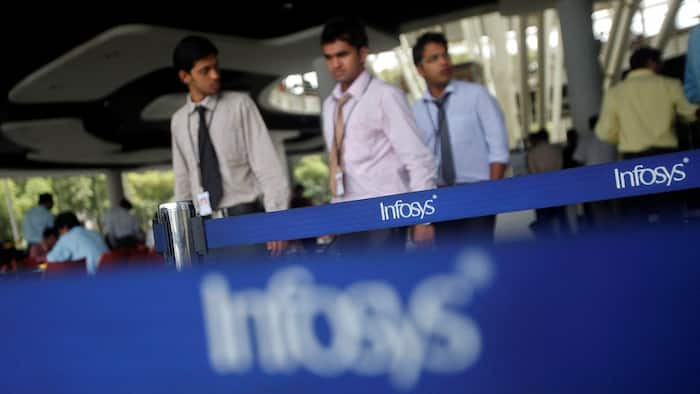 An employee walks past a signage board in the Infosys campus at the Electronics City IT district in Bengaluru.